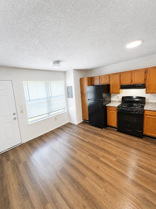A kitchen with black appliances and wooden cabinets.