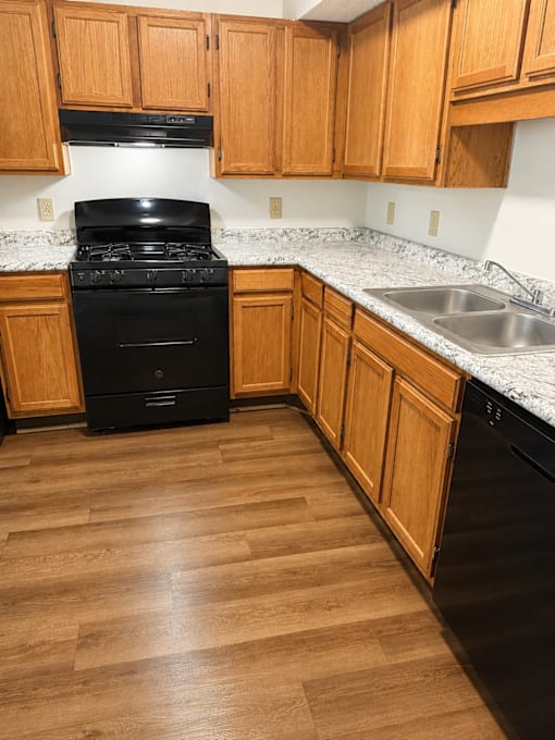 A black stove in a kitchen with wooden cabinets.