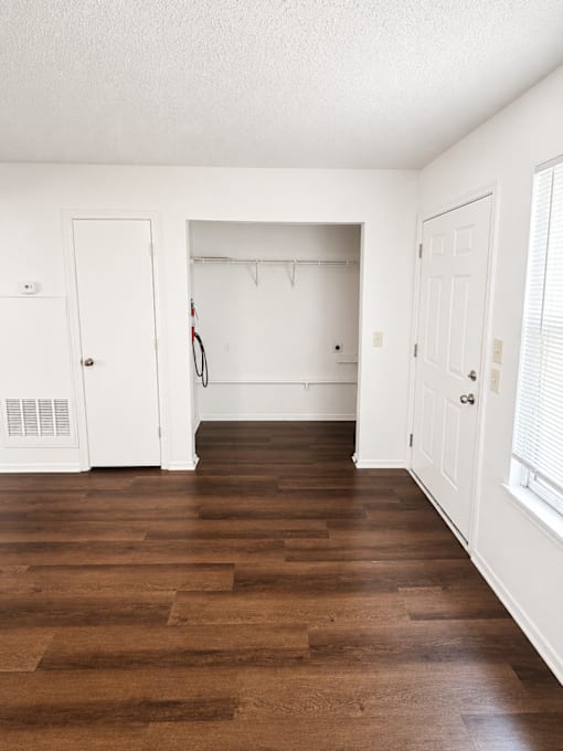 A room with white walls and a brown floor.