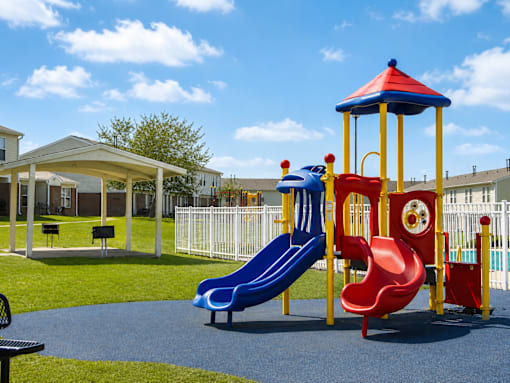 A playground with a red slide and a blue slide.