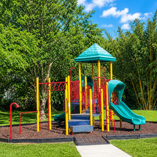 A playground with a green slide and a blue roofed structure.