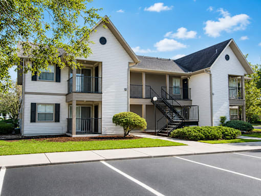 A two-story apartment building with a parking lot in front.