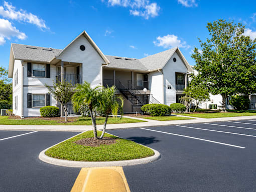 A white apartment building with a yellow curb in front.