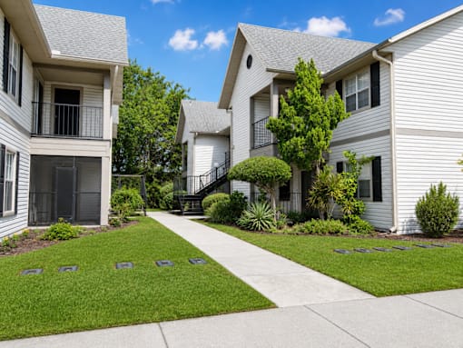 A row of houses with a sidewalk in front.