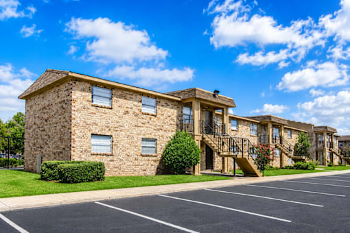 A large stone building with a parking lot in front.