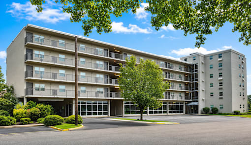A large apartment building with a parking lot in front.