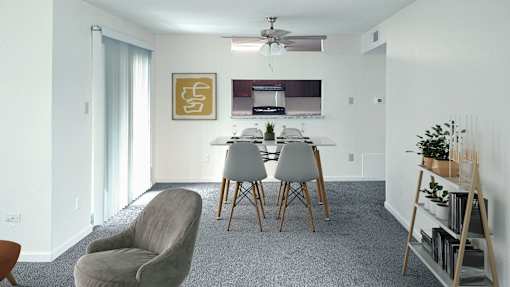 A living room with a grey carpet and a grey chair.