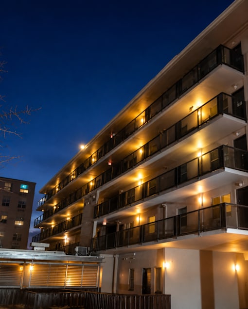 A building with balconies lit up at night.