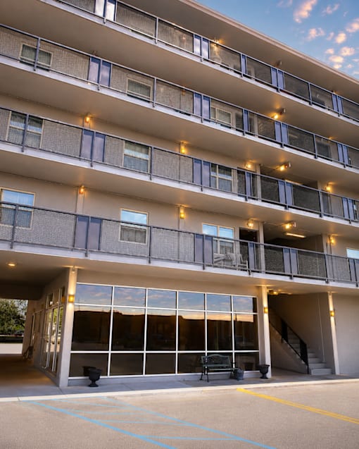 A large building with a lot of windows and lights on the balcony.