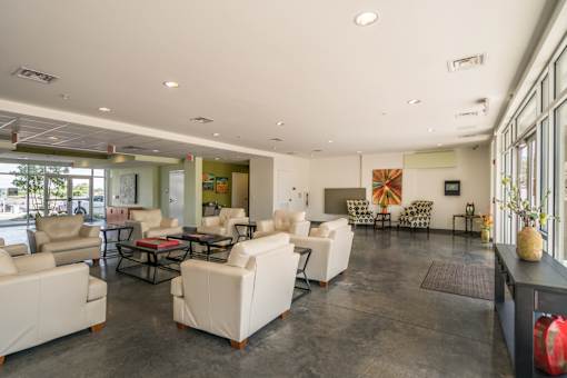 A spacious living room with white furniture and a fireplace.