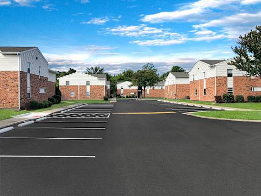 A parking lot with a road in the middle and buildings on both sides.