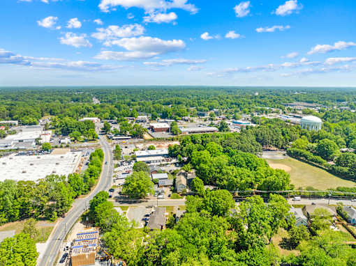 A bird's eye view of a town with a mix of greenery and buildings.