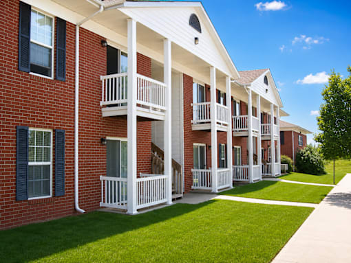 A row of red brick houses with white porches.
