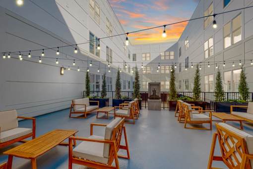 A sunny day at the rooftop terrace with wooden chairs and tables.
