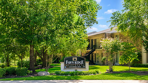A sign that says "Fawne Ridge" in front of a house.