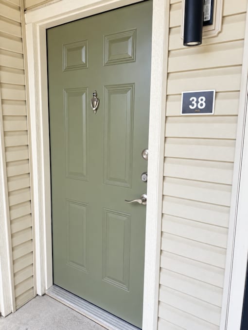 A green door with a number 38 on the wall above it.