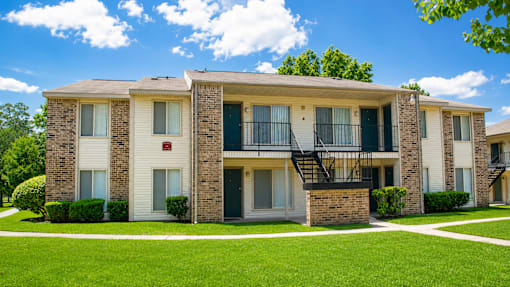 Apartment building with a green lawn in front.
