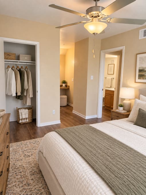 A bedroom with a large bed and a ceiling fan.