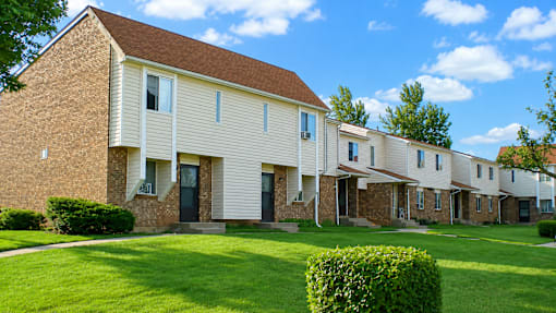 A row of houses with green lawns in front.