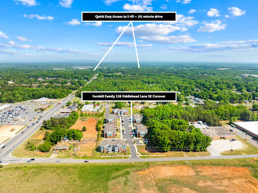 An aerial view of a construction site with a road leading to a building and a sign indicating a quick access to 40-60 minutes drive.
