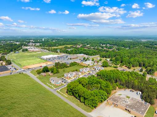 A bird's eye view of a small town with a large green field in the foreground.