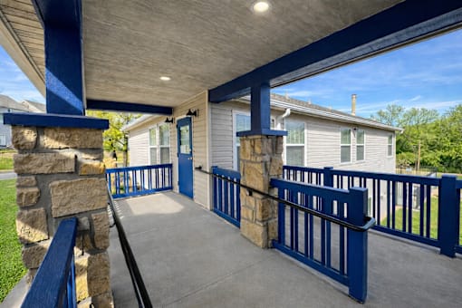 A blue and white house with a covered walkway.
