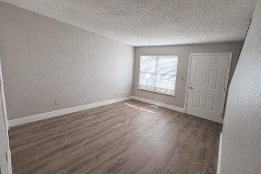 A room with a wooden floor and a white door.