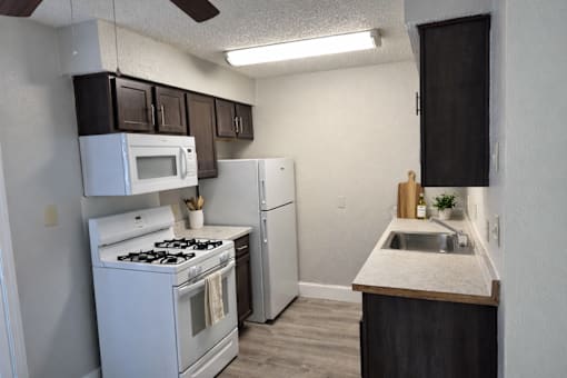 A kitchen with a white stove and a white refrigerator.