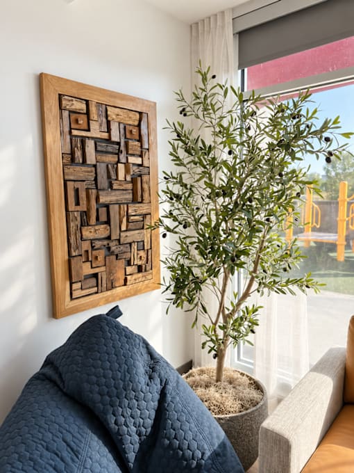 A living room with a couch and a tree.