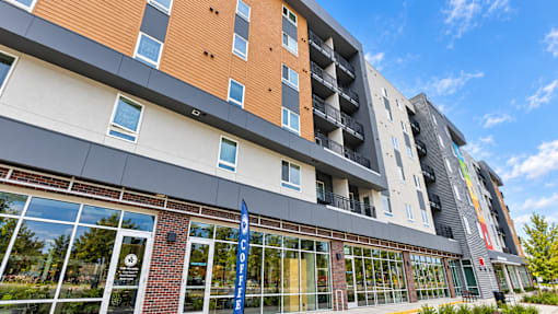 A modern building with a blue and white sign on the ground.