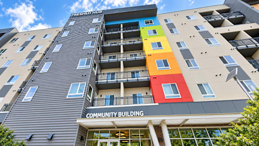 A multi-story building with a colorful design on the side and a sign that reads "Fishhooks".