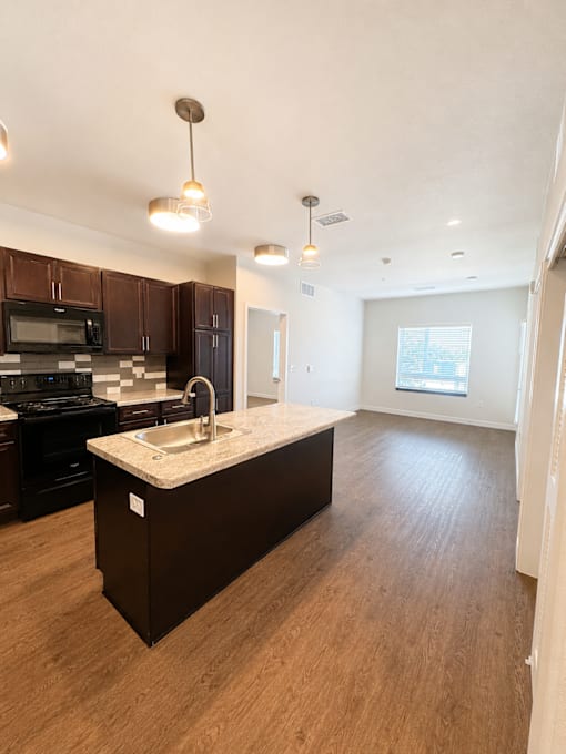A kitchen with dark brown cabinets and a white countertop.