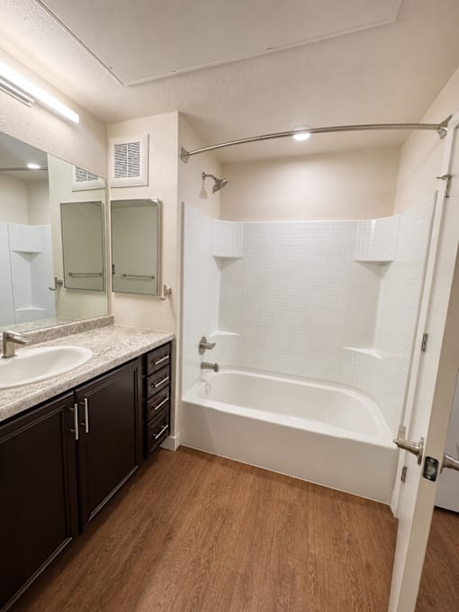 A white bathroom with a white tub and a white sink.