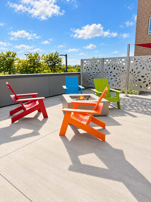 Four colorful chairs are arranged on a patio.