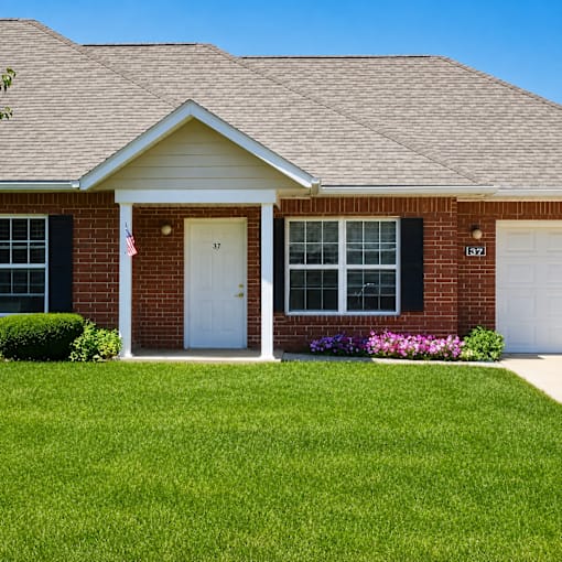A house with a white door and windows with black shutters.