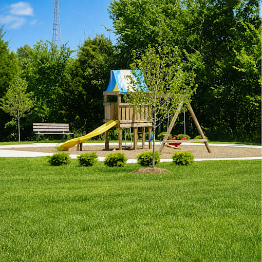 A playground with a yellow slide and a blue roof.