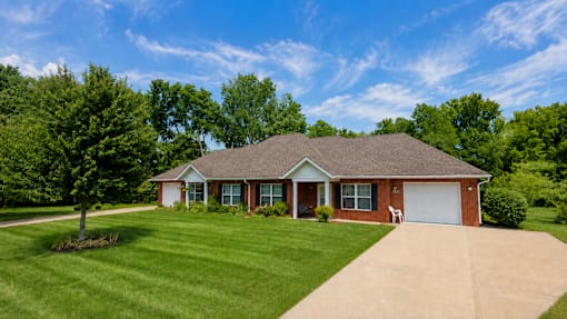 A house with a red brick exterior and a white garage door.