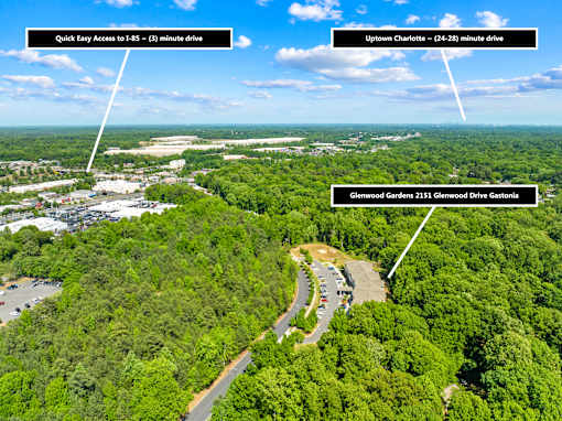 An aerial view of a wooded area with a road and three white arrows pointing to text boxes with addresses and driving times.