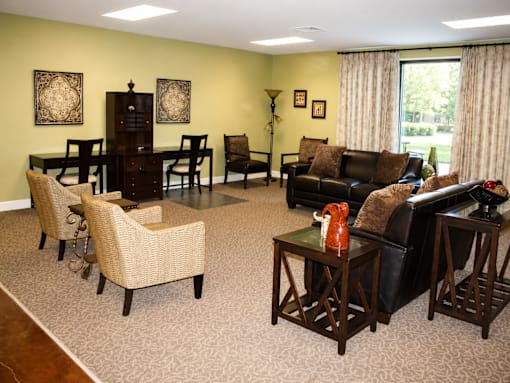 A living room with a black couch, a coffee table, and a dining table with chairs.