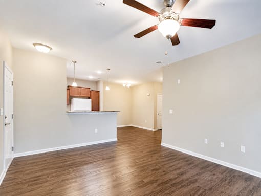 A room with a ceiling fan and wooden flooring.