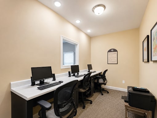 A room with a desk and chairs with a window.