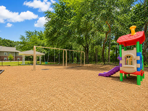 A playground with a slide, swings, and a climbing frame.