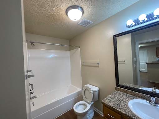 A white bathtub with a toilet and sink in a bathroom.