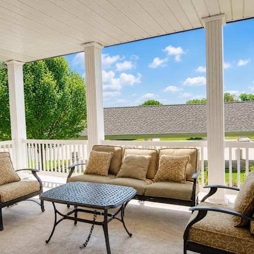 A patio with a table and chairs with a view of the backyard.