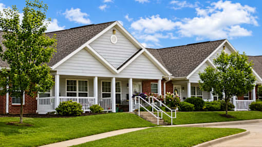 A white house with a grey roof and a small porch.