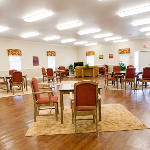 A room with red chairs and wooden floors.