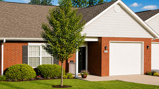 A house with a white garage door and a tree in front.