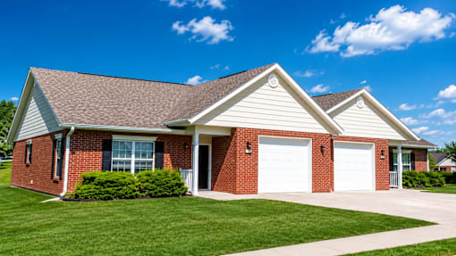 A red brick house with a white garage door.