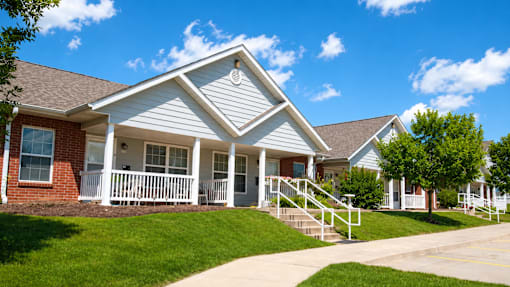 A house with a white porch and a brown roof.