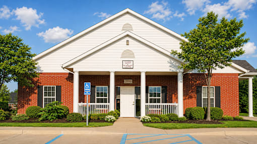 A church with a white steeple and a blue handicap sign in front.